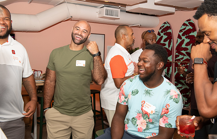 A group of alumni laugh together